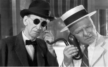 Close-up of Mr. Muckle with Harold Bissonette listening to very old earpiece.