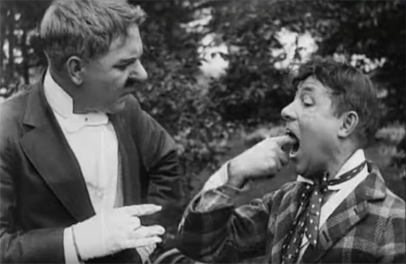 Film still showing the Pool Shark missing a finger and the Pool Adversary feeling for it in his mouth.